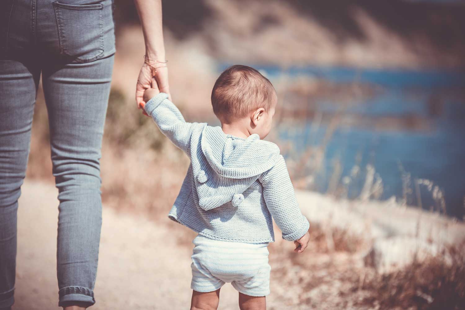 Un enfant marche aux côtés d'un parent Un enfant marche aux côtés d'un parent