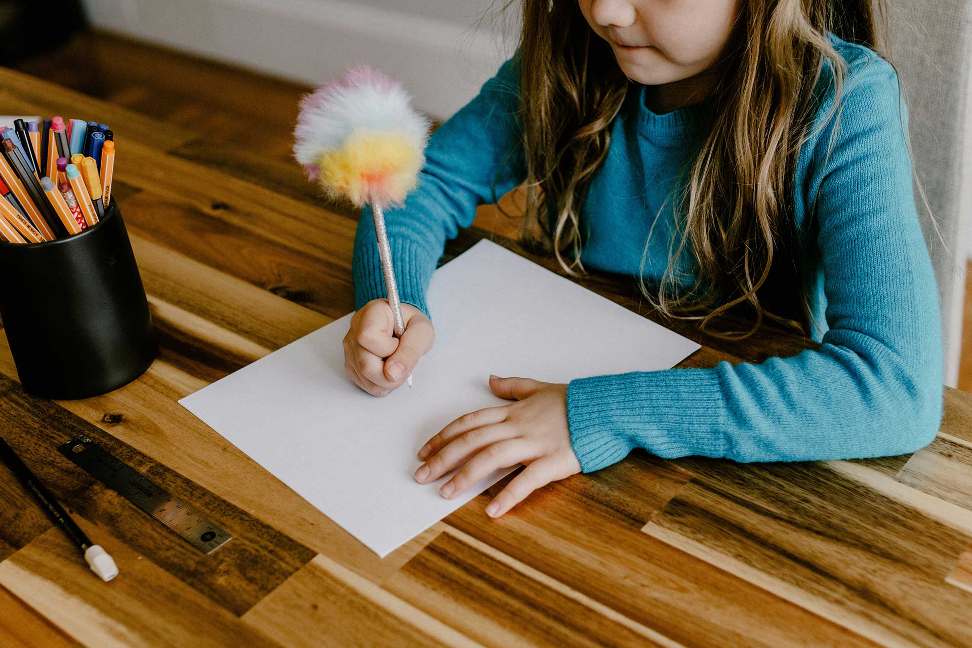 Un enfant dessine sur une feuille de papier Un enfant dessine sur une feuille de papier